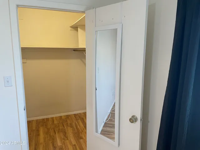a view of a livingroom with wooden floor and a ceiling fan