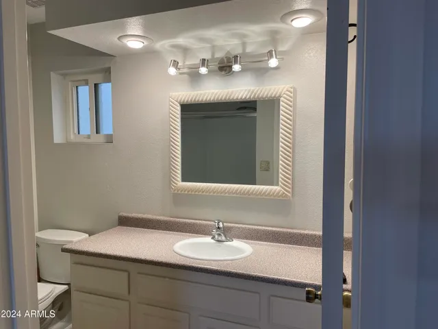 a view of an empty room with wooden floor and a chandelier