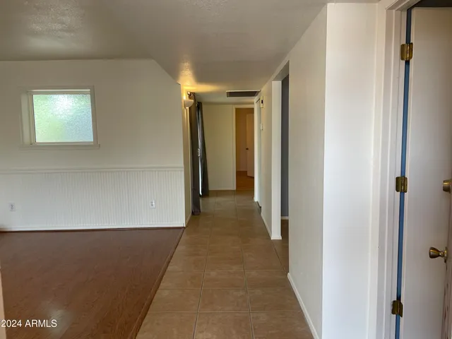 an empty room with a fireplace and chandelier fan
