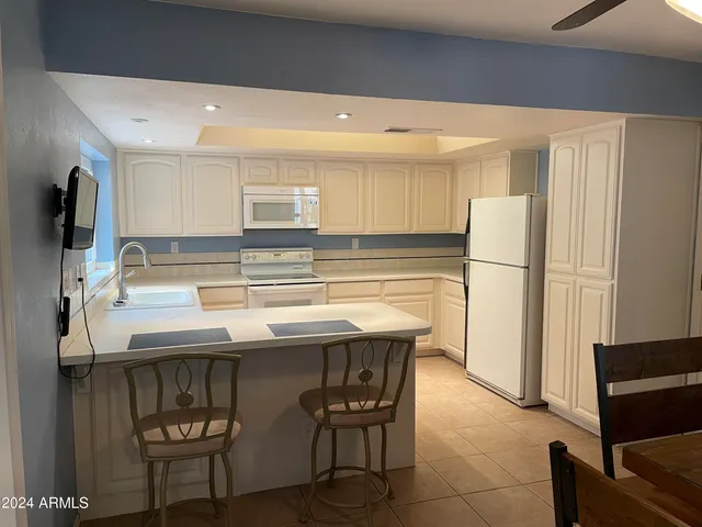 a kitchen with a sink and chairs