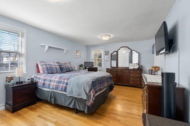 a spacious bedroom with a bed and a flat screen tv