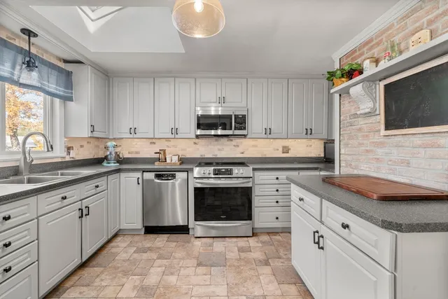 a kitchen with cabinets stainless steel appliances and a sink
