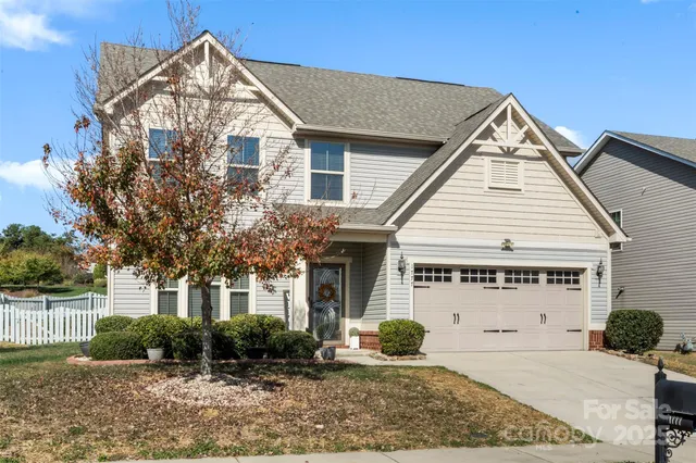 a view of a white house with a yard and plants