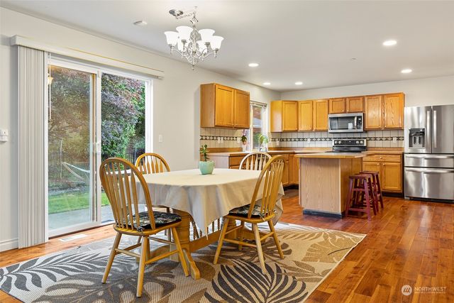 a kitchen with stainless steel appliances granite countertop a stove top oven a sink and a refrigerator