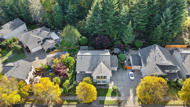 an aerial view of a house with a yard and large tree
