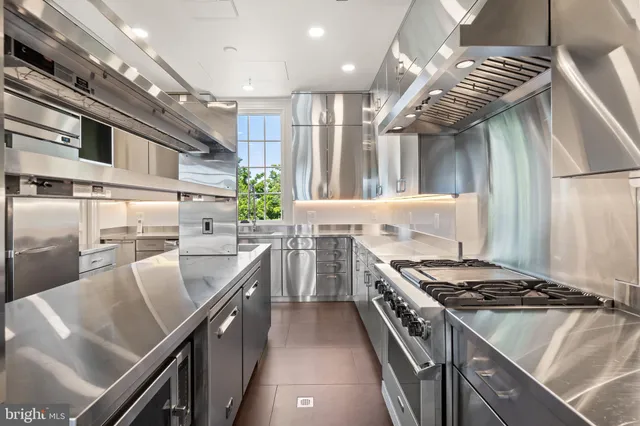 a kitchen with stainless steel appliances granite countertop a sink a stove and a table