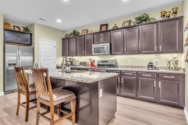 a kitchen with granite countertop a sink stove and cabinets