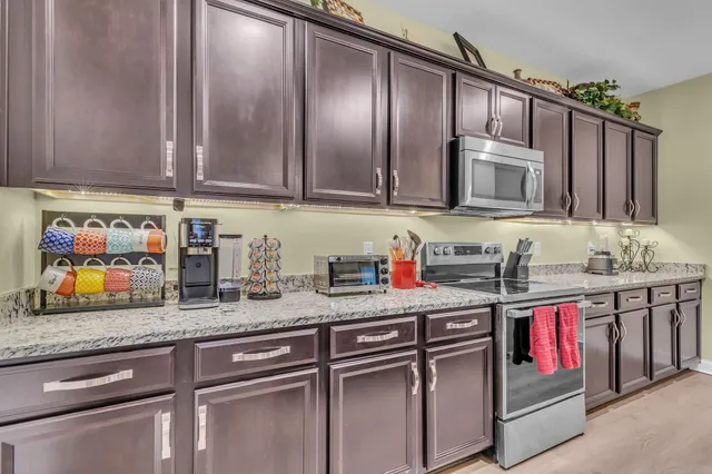 a kitchen with stainless steel appliances granite countertop a sink stove and cabinets