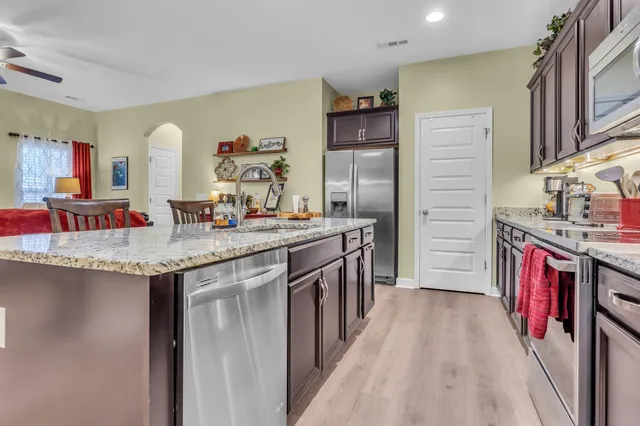 a kitchen with stainless steel appliances granite countertop a sink stove and refrigerator