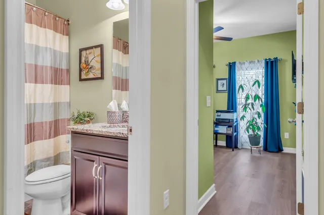 a bathroom with a granite countertop sink a toilet and shower