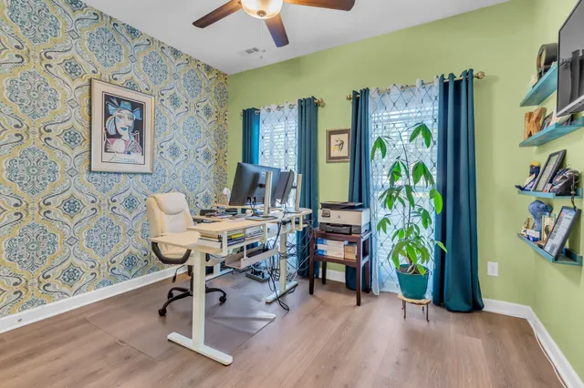 a workspace with furniture and paintings on the wall