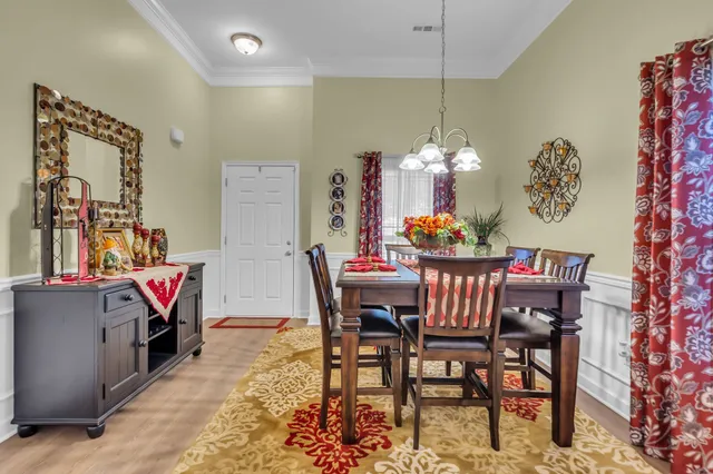 a dining room with furniture a chandelier and window