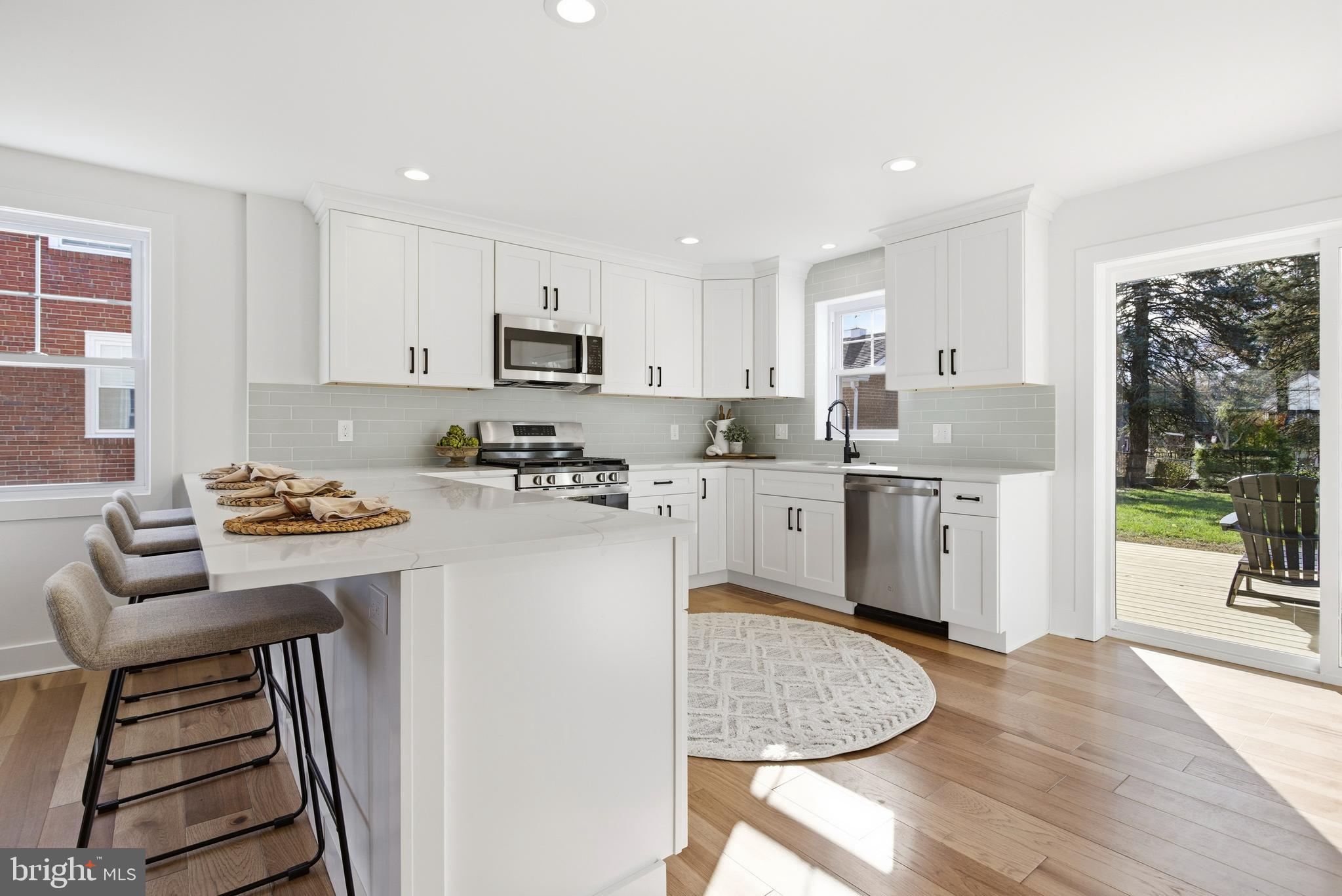 338 Wayne Avenue Springfield, PA 19064 - Photo 7 of 34 a kitchen with kitchen island a stove a sink and a refrigerator