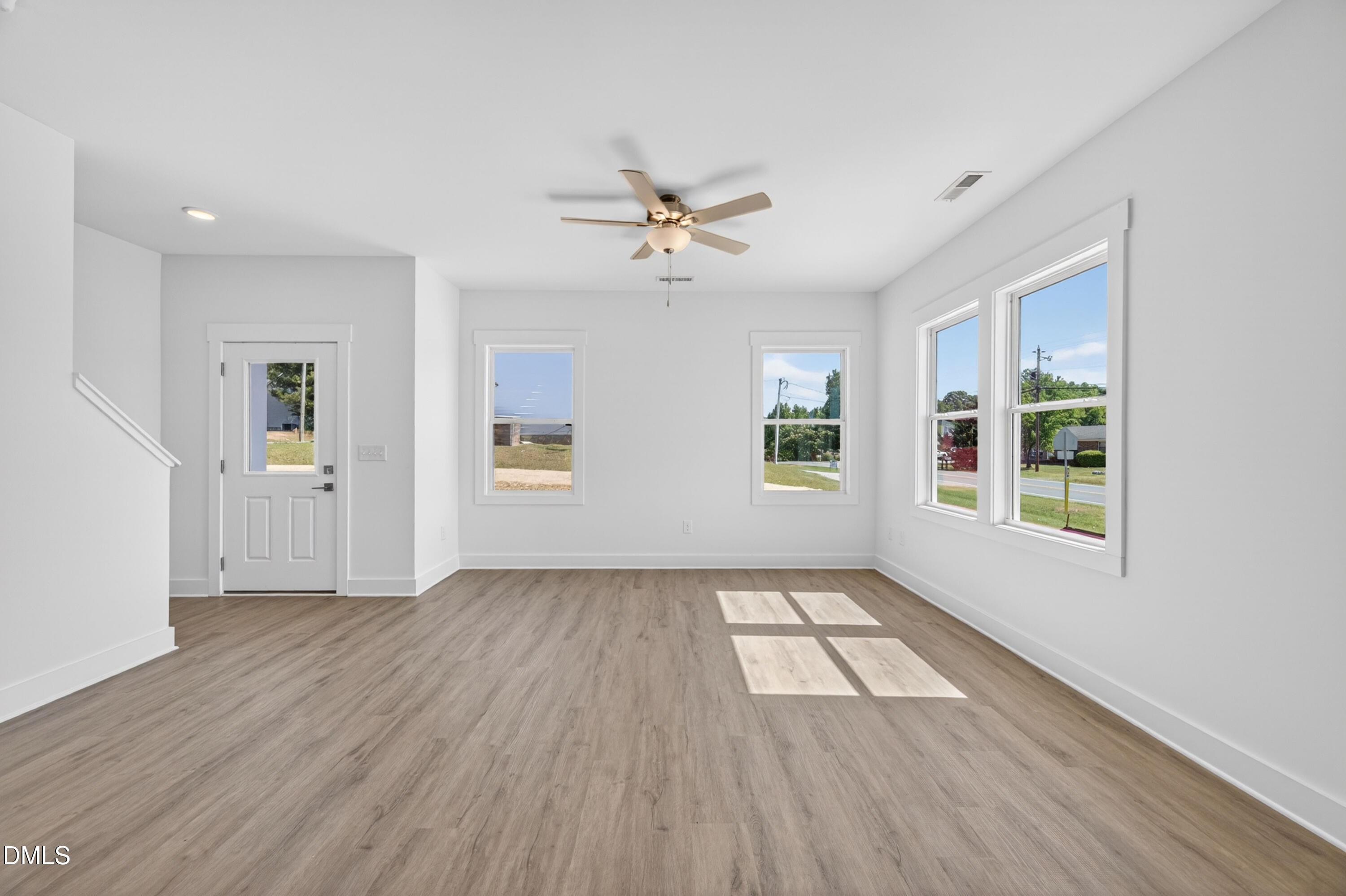 1238 Hurdle Mills Road Roxboro, NC 27573 - Photo 11 of 50 an empty room with wooden floor chandelier fan and windows