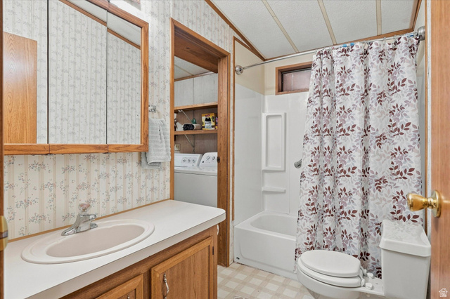 2405 Canyon Road Smithfield, UT 84335 - Photo 18 of 57 Bathroom featuring a single vanity with a laminate countertop, built-in medicine cabinet, white bathtub with a shower, and patterned wallpaper