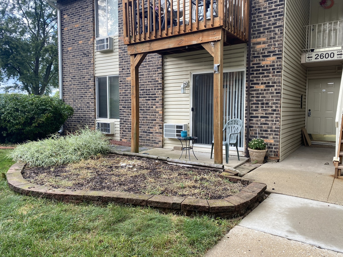 2600 Light Road, Unit 107 Oswego, IL 60543 - Photo 1 of 8 a view of a house with a small yard and plants