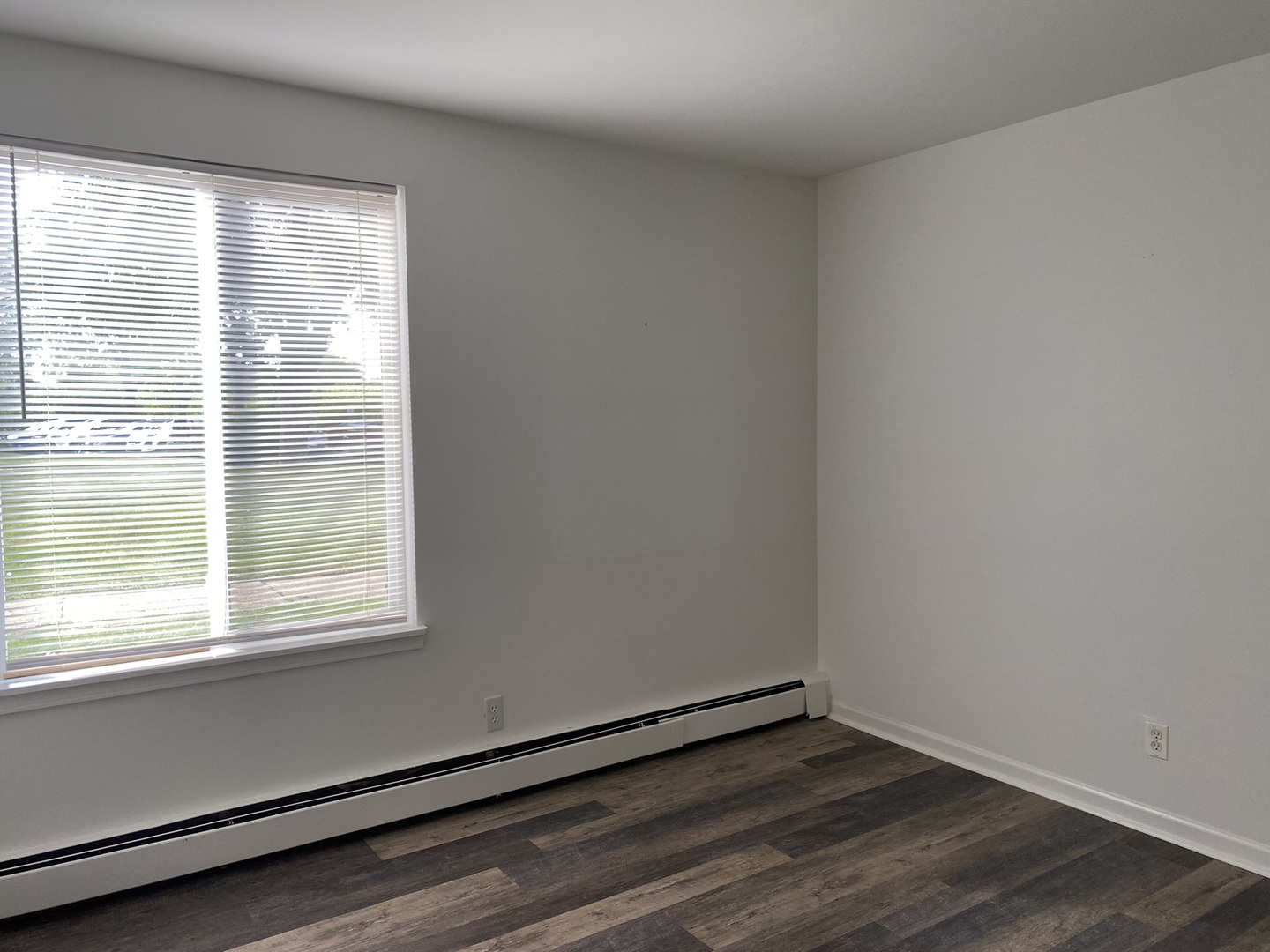 2600 Light Road, Unit 107 Oswego, IL 60543 - Photo 2 of 8 a view of an empty room with wooden floor and a window
