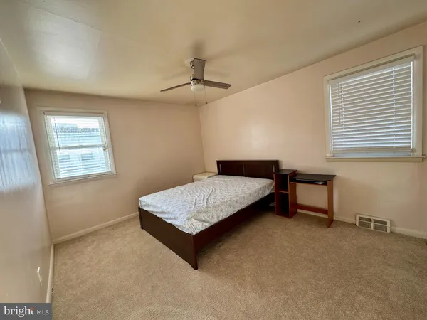 a bedroom with a bed a dresser and a window