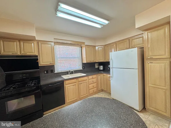 a kitchen with granite countertop a refrigerator stove and microwave
