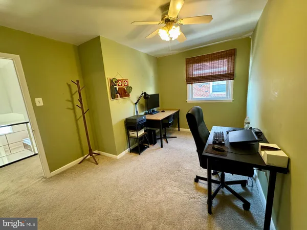 a view of a workspace with furniture and a window