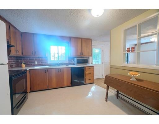 83 Lincoln Road Sutton, MA 01590 - Photo 7 of 22 a kitchen with granite countertop a stove a sink and a refrigerator