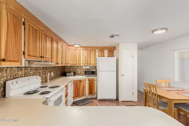 a room with furniture a refrigerator and wooden floor