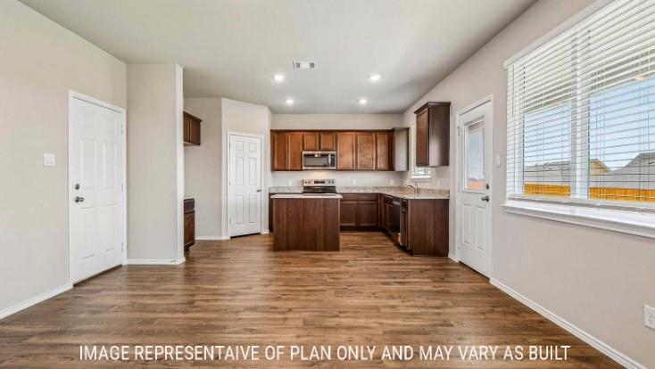 10101 Altair Drive Waco, TX 76708 - Photo 10 of 36 Wood-finish flooring throughout, kitchen with dark wood cabinetry, stainless steel appliances, and stone-look countertops