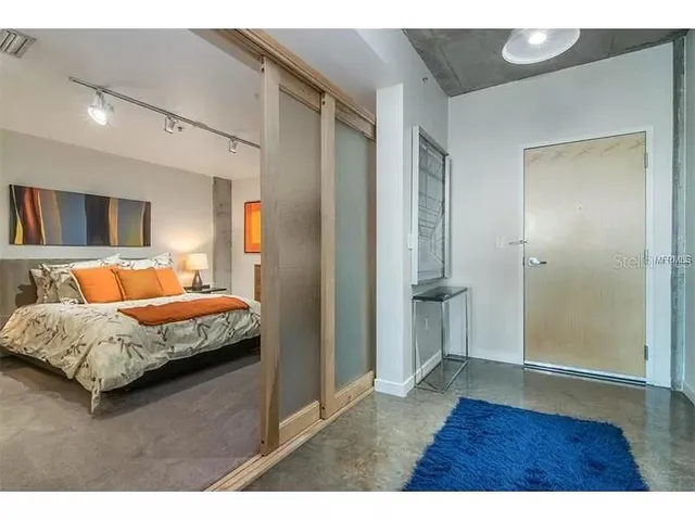 a bedroom with a bed a couch and a flat screen tv