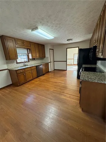 a kitchen with stainless steel appliances kitchen island granite countertop a refrigerator and stove