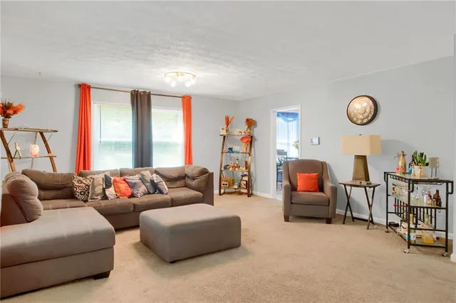a living room with furniture a table and a large window