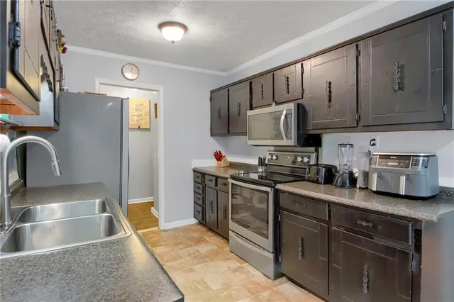a kitchen with stainless steel appliances granite countertop a sink stove and refrigerator