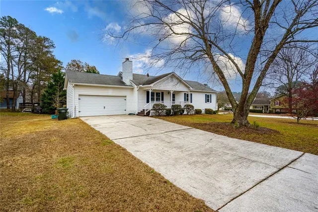 a view of large house with a yard covered with snow and trees