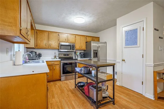 a kitchen with stainless steel appliances a stove a sink refrigerator and a microwave