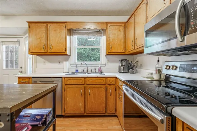 a kitchen with stainless steel appliances granite countertop a sink stove and cabinets