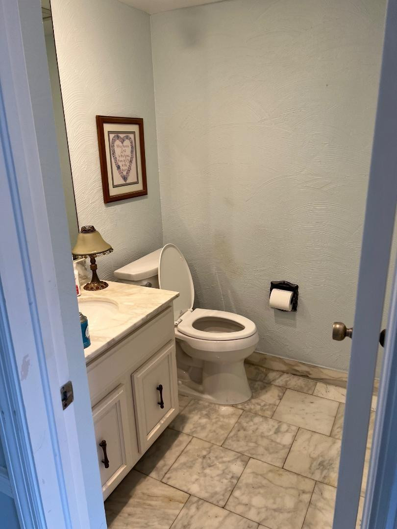 899 Jeffery Street, Unit 703 Boca Raton, FL 33487 - Photo 7 of 22 a bathroom with a granite countertop toilet and a sink