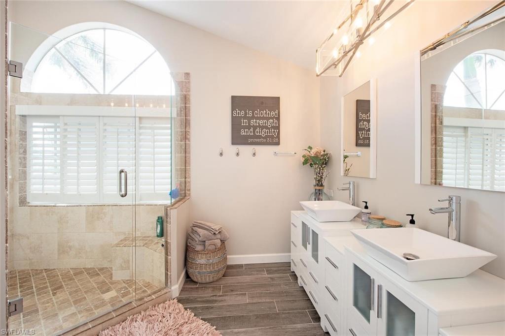 437 Trade Winds Avenue Naples, FL 34108 - Photo 19 of 33 a spacious bathroom with double vanity and a mirror