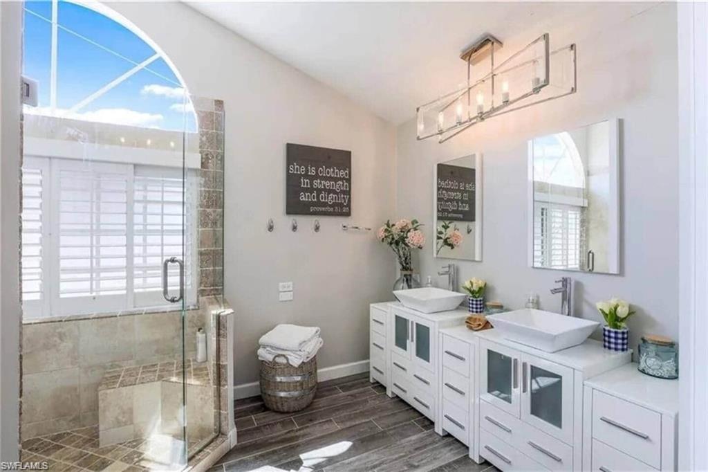437 Trade Winds Avenue Naples, FL 34108 - Photo 23 of 33 a bathroom with a double vanity sink a toilet and a shower