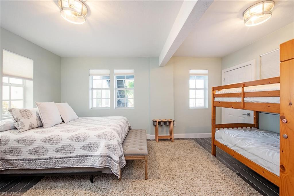 437 Trade Winds Avenue Naples, FL 34108 - Photo 24 of 33 a bedroom with a bed and a dresser next to a window