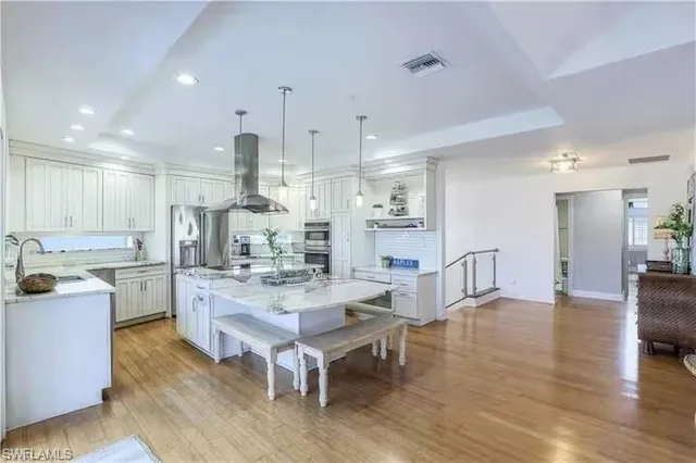 a large kitchen with cabinets wooden floor and stainless steel appliances