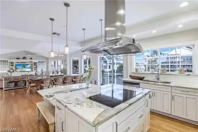 a kitchen with stainless steel appliances granite countertop a sink a stove and a wooden floors
