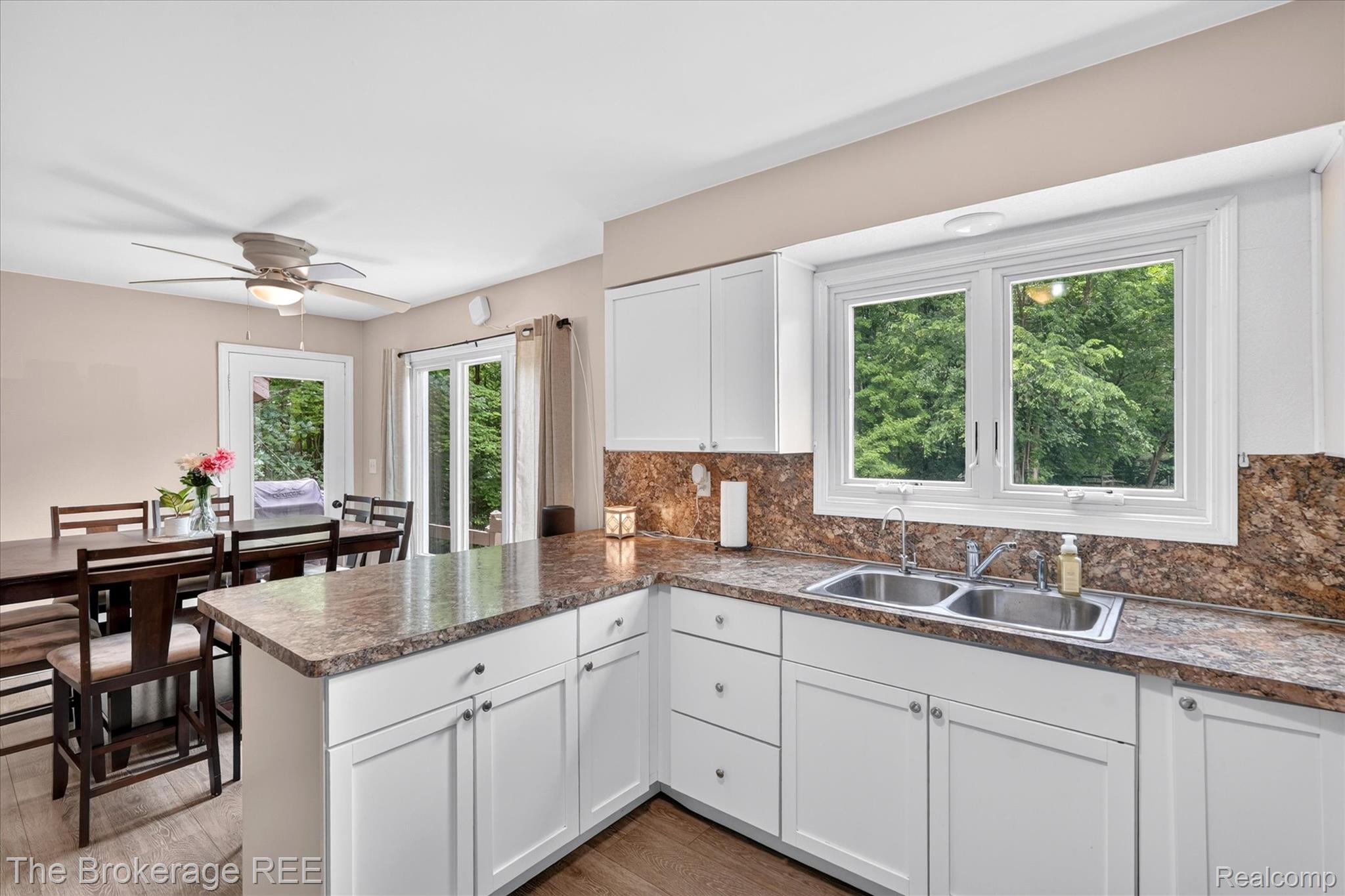 13269 North Genesee Road Clio, MI 48420 - Photo 18 of 67 Kitchen featuring white cabinetry, stone-finish countertops, a double basin stainless steel sink, and wood-finish flooring