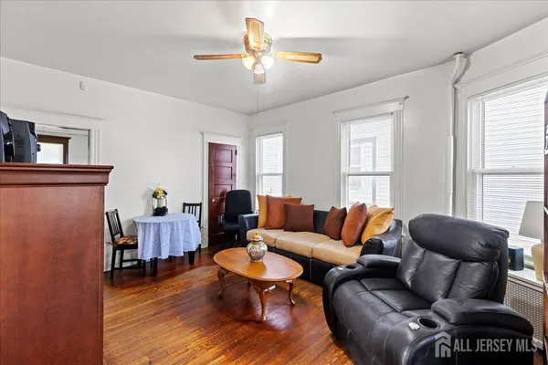 a bedroom with a bed a desk and chair with wooden floor