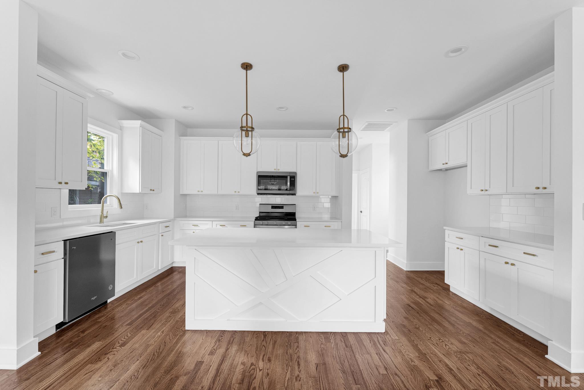 2311 Poole Road Raleigh, NC 27610 - Photo 11 of 29 a large kitchen with cabinets wooden floor and stainless steel appliances