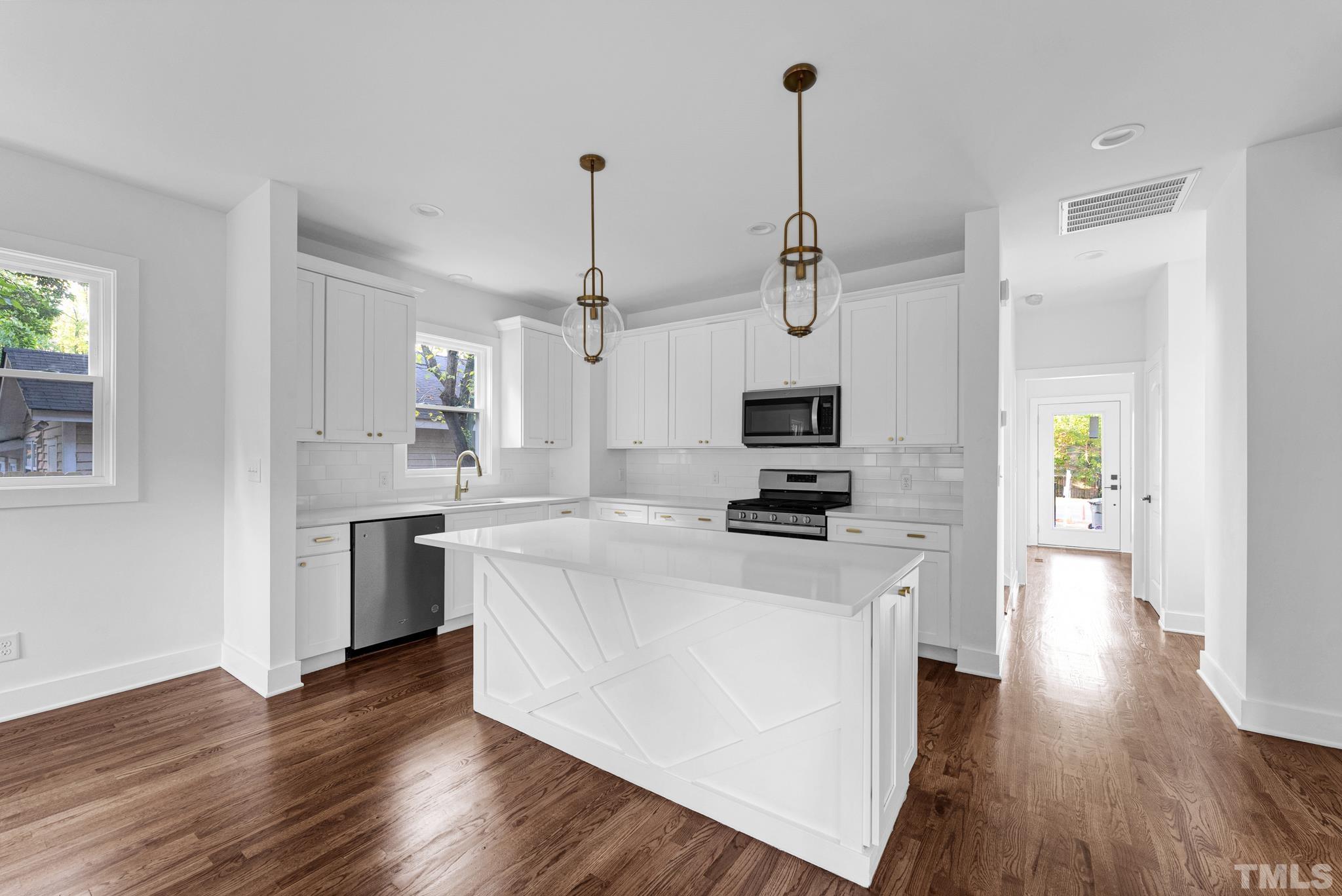2311 Poole Road Raleigh, NC 27610 - Photo 8 of 29 a kitchen with stainless steel appliances kitchen island a stove a sink a refrigerator and a wooden floor