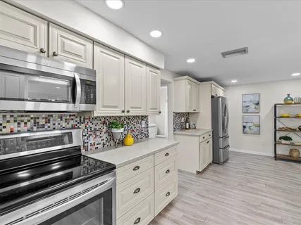 a kitchen with stainless steel appliances a stove a microwave and cabinets