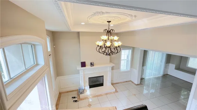a view of a livingroom with a fireplace a chandelier and stairs