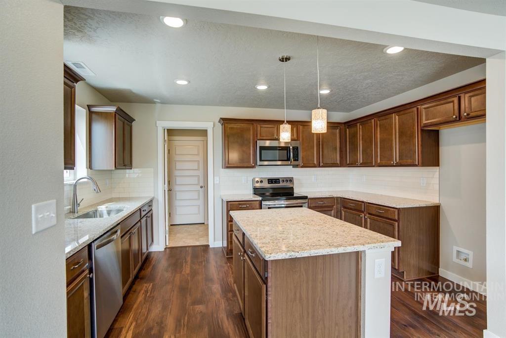 1589 Witt Mountain Mountain Home, ID 83647 - Photo 7 of 7 Kitchen featuring stainless steel appliances, a kitchen island, dark wood-style flooring, tasteful backsplash, and recessed lighting
