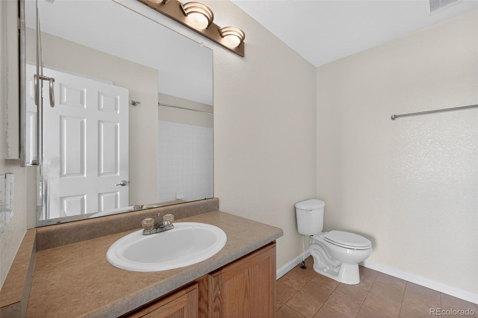 6603 Autumn Ridge Drive, Unit 2 Fort Collins, CO 80525 - Photo 28 of 33 a bathroom with a granite countertop sink toilet and a mirror