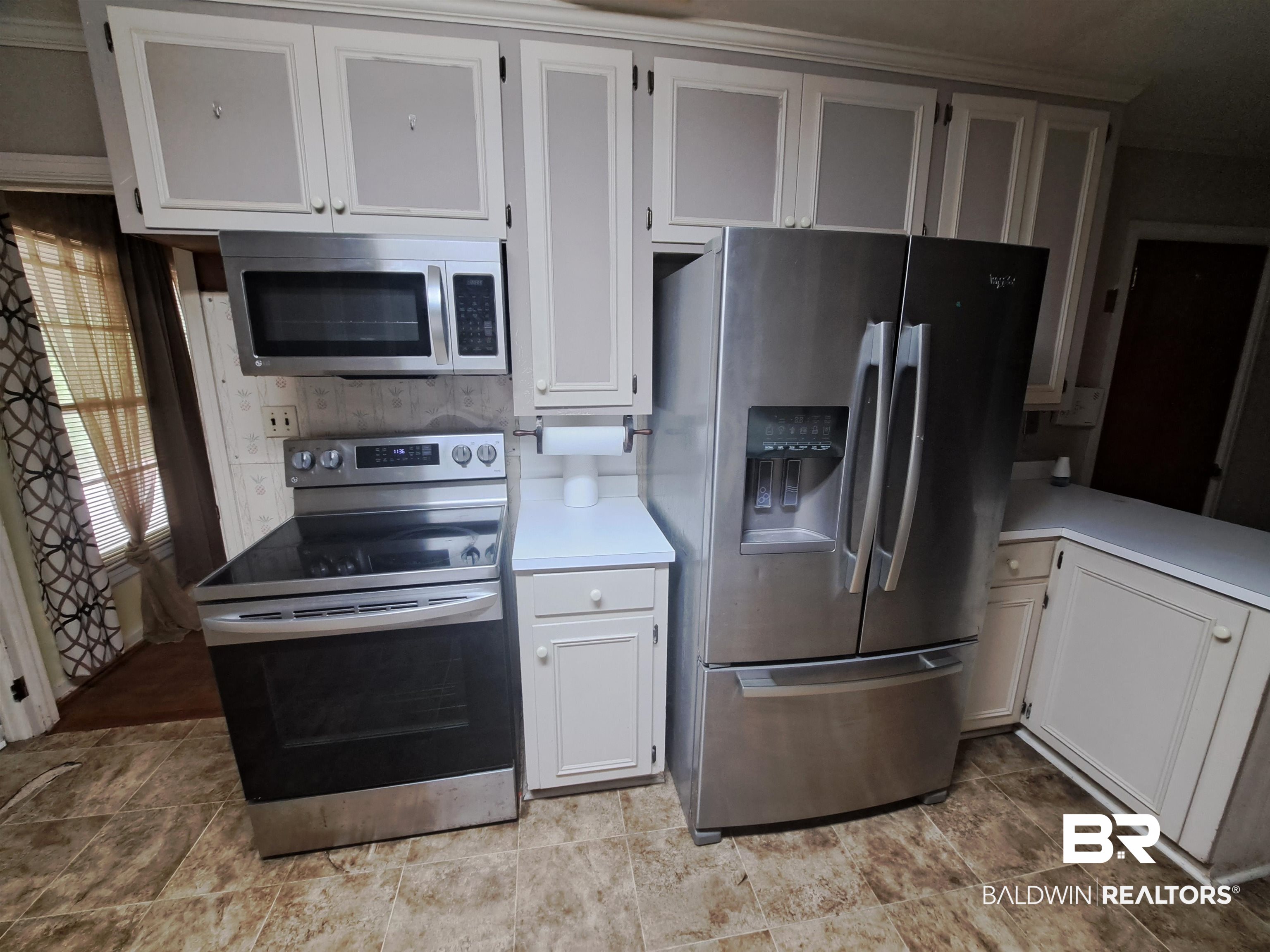 249 Newton Parkway Evergreen, AL 36401 - Photo 7 of 28 Kitchen with appliances with stainless steel finishes, white cabinetry, and light countertops