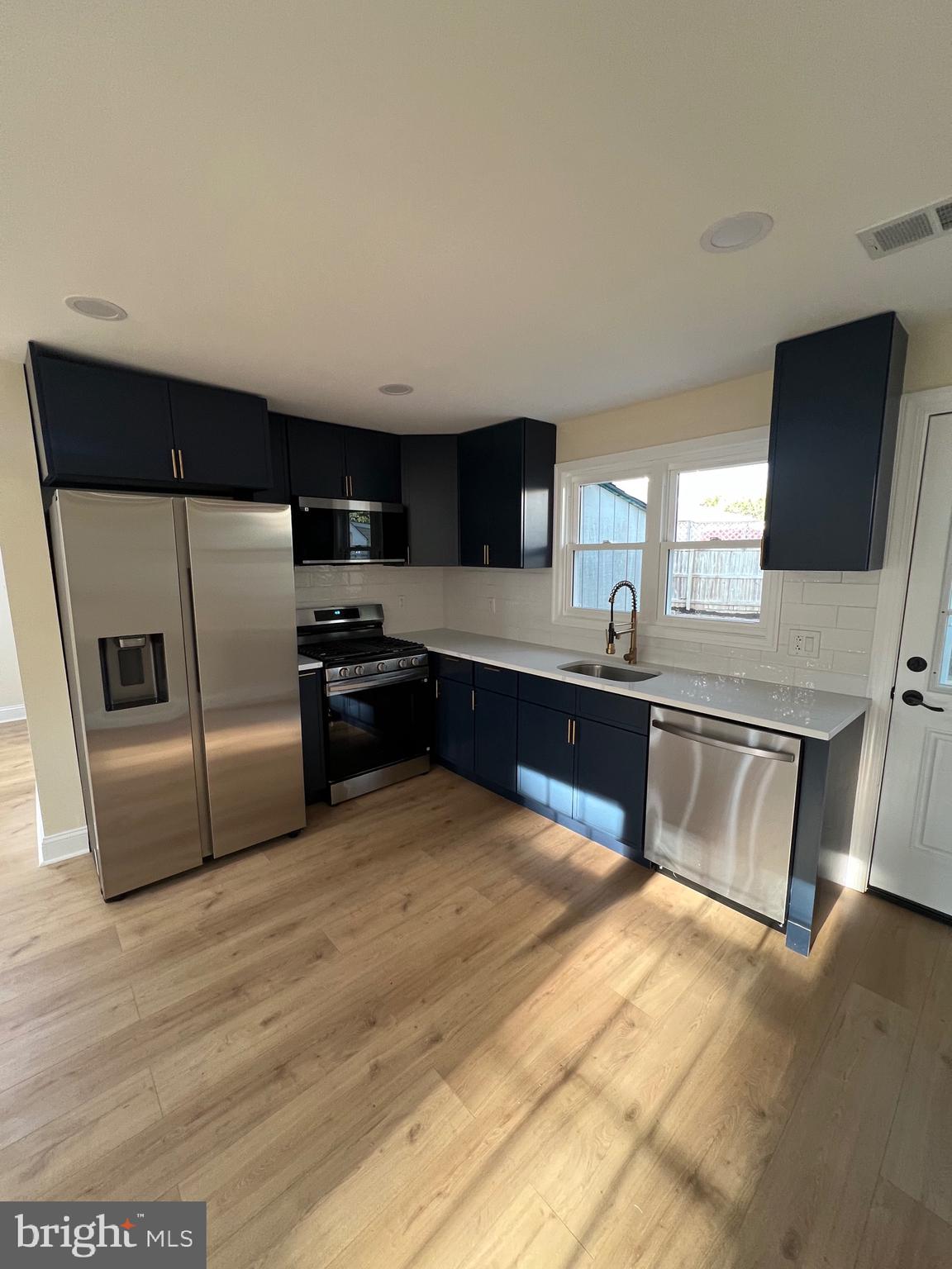 810 Quince Lane Secane, PA 19018 - Photo 25 of 44 a kitchen with granite countertop a refrigerator and a stove top oven
